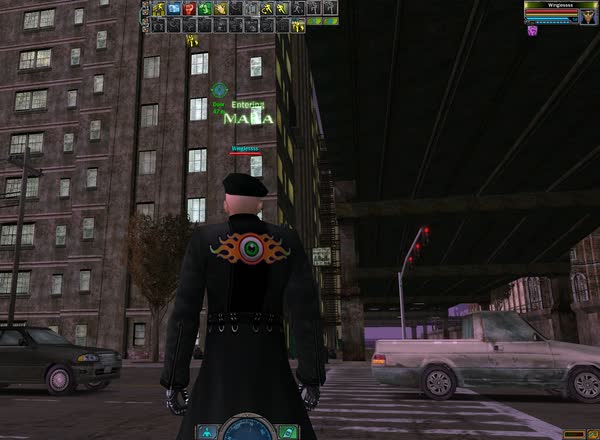 An operative with a flaming eye on his coat stands on a Mara street under an elevated railway at night.